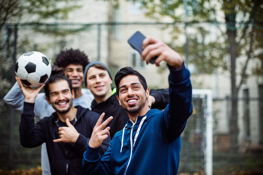 Smiling players taking selfie through mobile phone