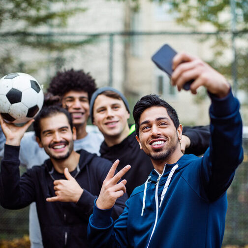 Smiling players taking selfie through mobile phone